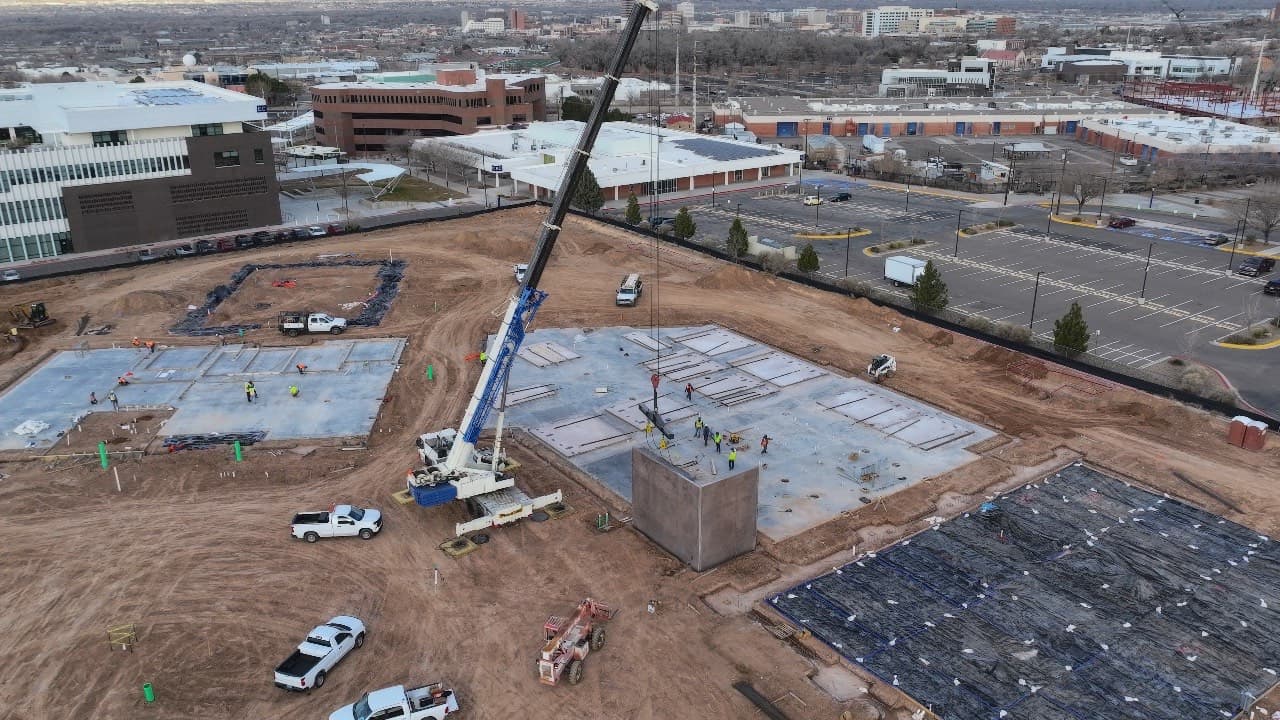 Drone orbit of the CNM Skilled Trades site during tilt-up, a crane among concrete casting beds