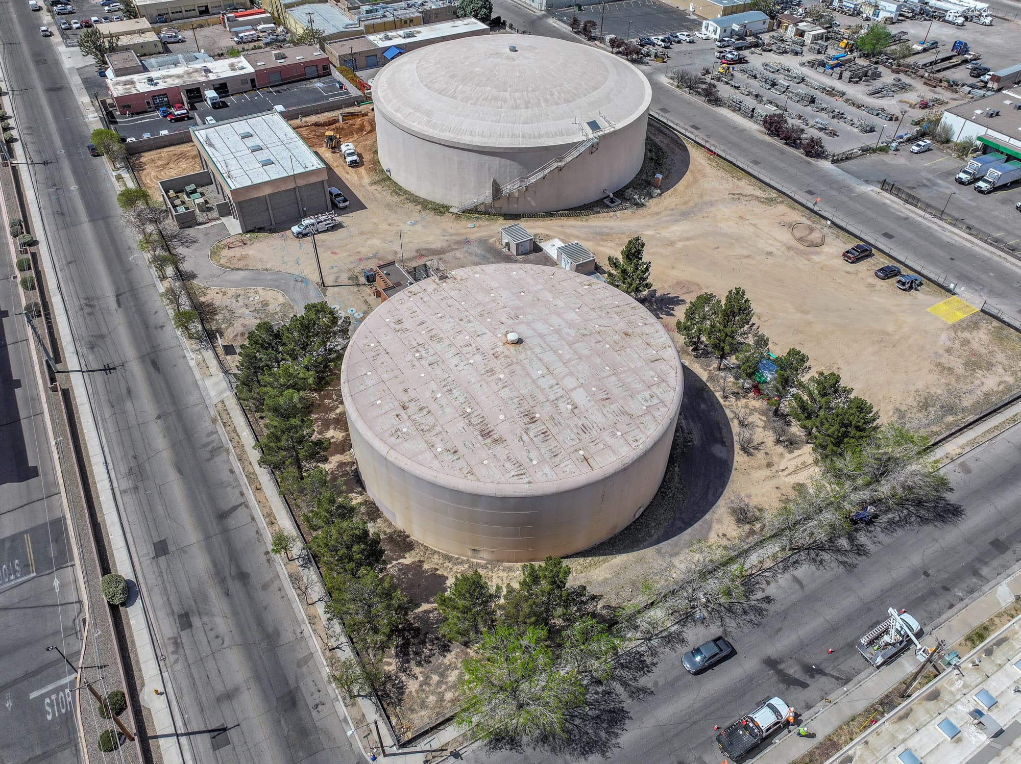 Overhead view of two round water tanks in a city block